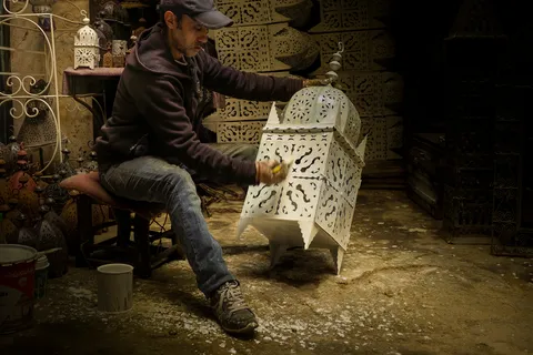 Artisan colouring a lamp